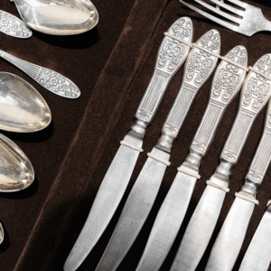 Antique spoons and knives arranged neatly