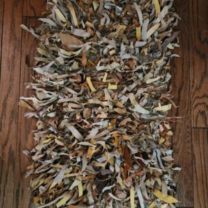 Hand-woven genuine leather throw rug in warm brown, beige, and taupe earth tones
